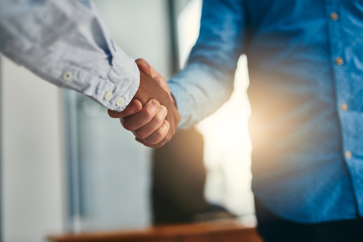 Businessman and prospective customer shaking hands in an office showing a concept of agreement regarding B2B deals.